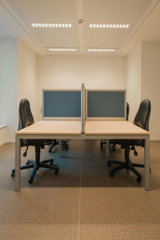 Contemporary office space featuring partitioned desks and ergonomic chairs.